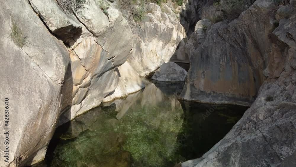 Flying inside mountain ponds in a narrow stone canyon Flying inside mountain ponds in a narrow stone canyon