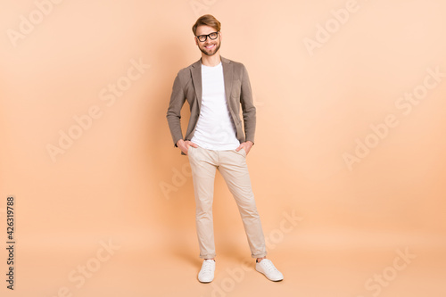 Full body photo of charming attractive young gentleman hold hand smile isolated on pastel beige color background