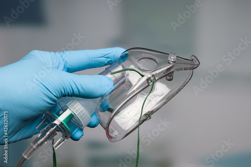Doctor's hand with disposable oxygen mask for breath support