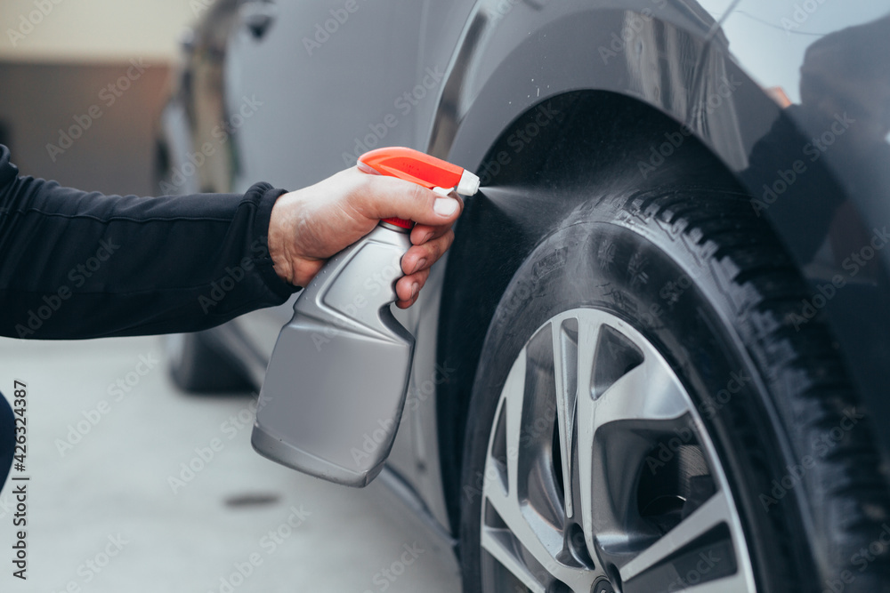 close up man cleaning car tires in carwash service close up man cleaning car tires in carwash service