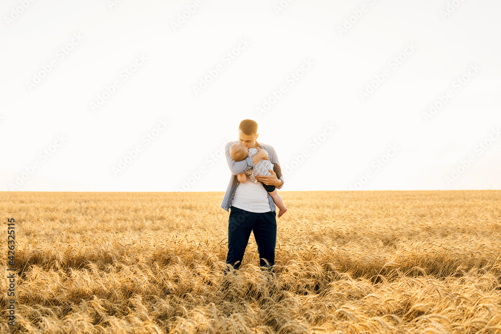 Happy family on a summer walk, mother, father and child walk in the wheat Happy family on a summer walk, mother, father and child walk in the wheat