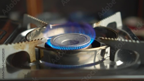 Kitchen burner turning on.Stove top burner igniting into a blue cooking flame. Natural gas inflammation, close up.