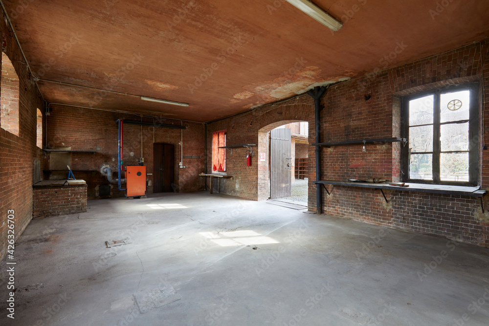 Old, empty workshop interior with brick walls in a sunny morning