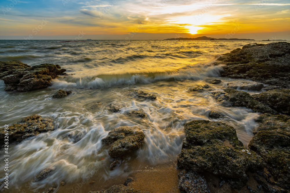 Sea waves crashed against rocks in the sunset at Pattaya Thailand.