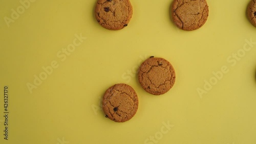 Oatmeal cookies move on a yellow seamless background. Cookies are a fun stop motion. Animated oatmeal cookies. Homemade sweet snacks.