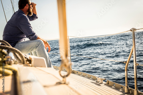 Foto Man sit down on sail boat deck and look far at the ocean - adult male people enj
