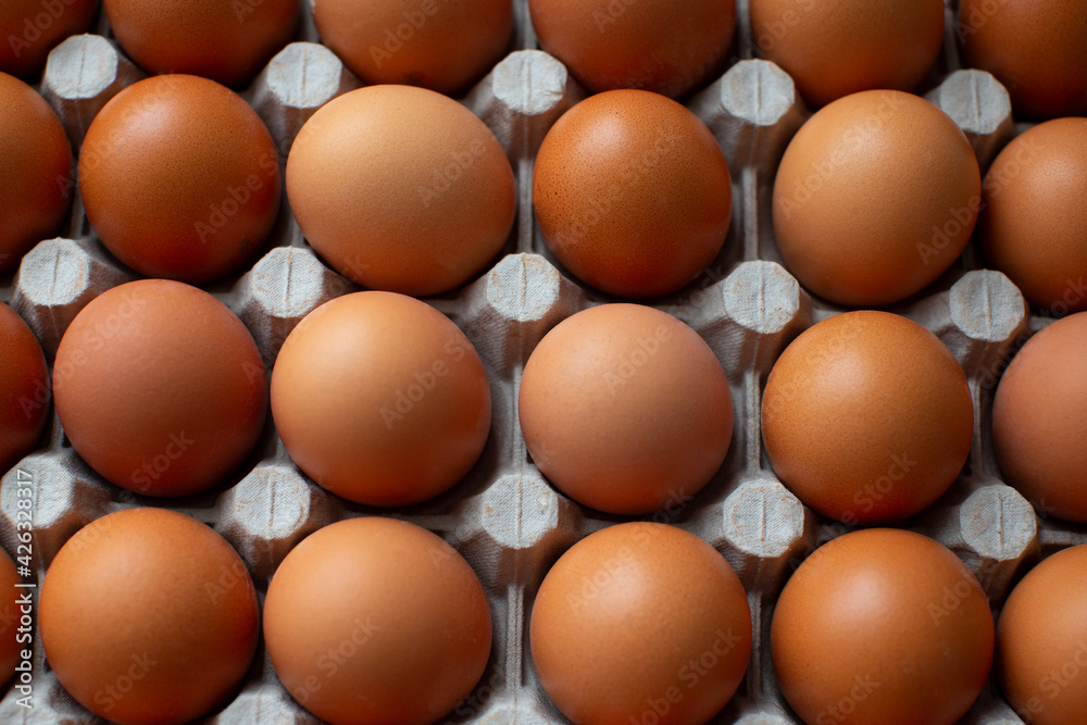 Rural, raw and fresh eggs in cartoon egg box tray, close-up with soft and select focus and isolated copy space. Rural, raw and fresh eggs in cartoon egg box tray, close-up with soft and select focus and isolated copy space.