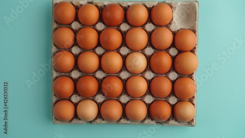 Eggs appear and disappear from cardboard box for eggs on blue background - Stop motion