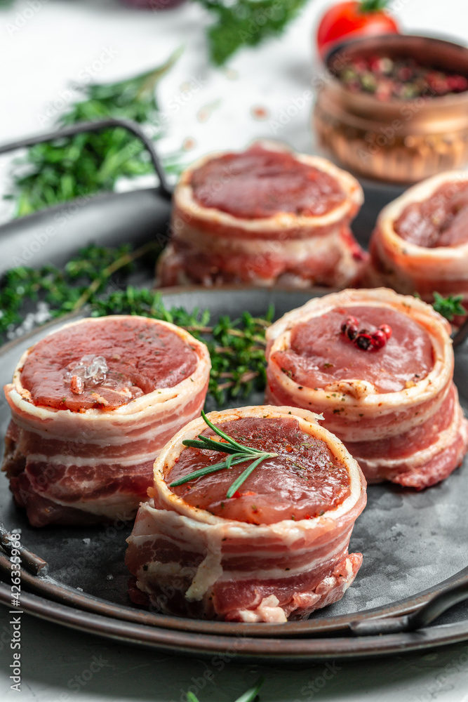 Raw fresh marbled meat Steak filet mignon. medallion steaks wrapped in bacon served on old metal tray. vertical image