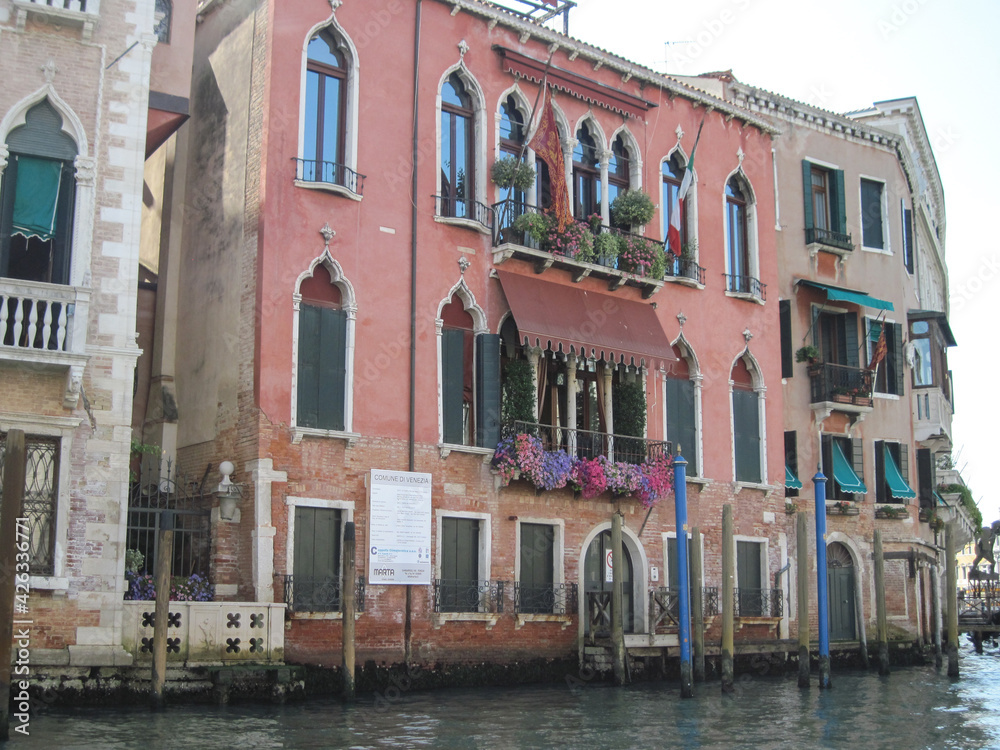 Venice old city grand canal with gondolas and boats. Romantic swimming in the morning. Comfotrable transportation to ancient historic hotel. Scenic Venetian scape on a sunny day.