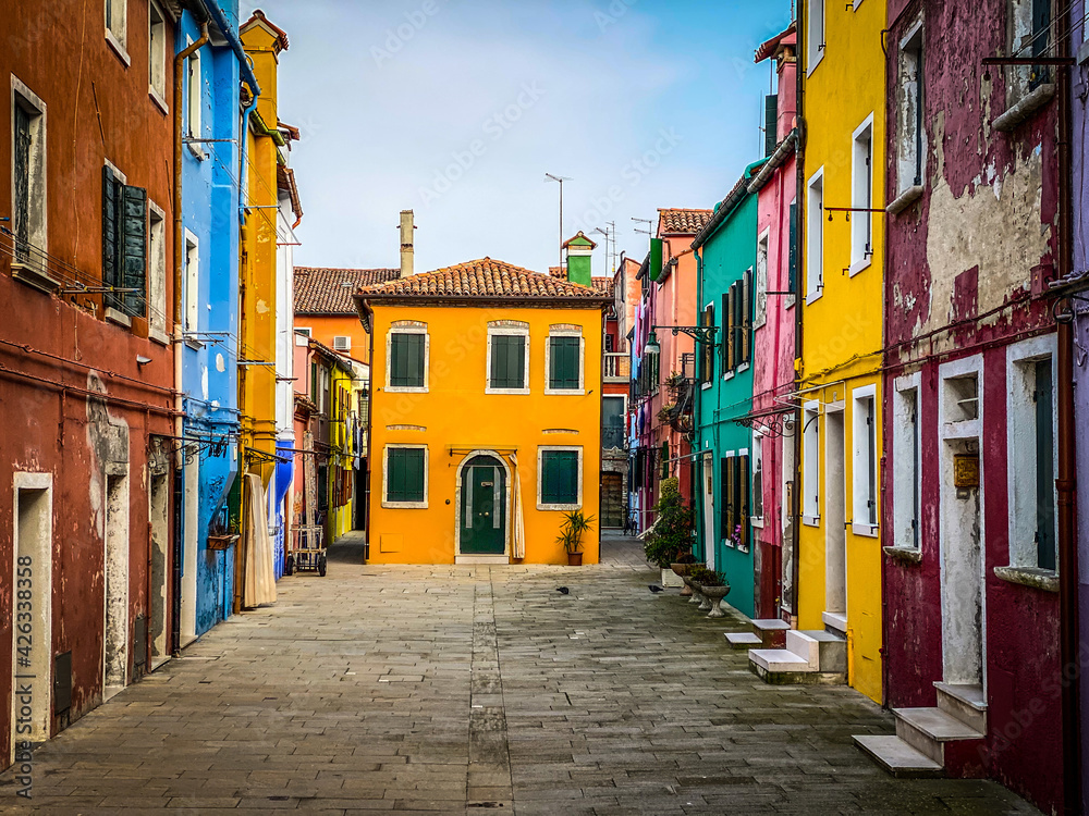 Colorful houses on a small traditional square at Burano island, Venice, Italy