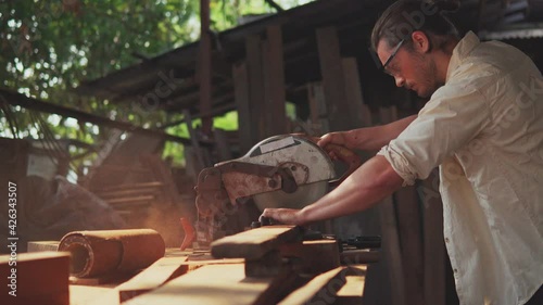 A carpenter cutting wooden plank with electric buzzsaw. Woodworking and carpentry. Craftsmanship.	
 photo