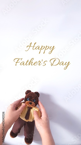 Happy Father's Day greeting card. Plush crochet teddy bear in a suit.