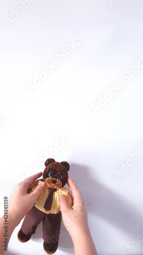 Plush crochet teddy bear in a suit.
Copy space.