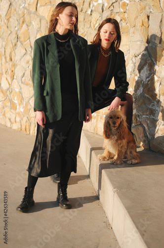 Two girls and english cocker spaniel dog.Portrait of dog outside (outdoors). Sunny day.