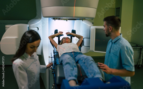 Cancer treatment in a modern medical private clinic or hospital with a linear accelerator. Professional doctors team working while the woman is undergoing radiation therapy for cancer photo