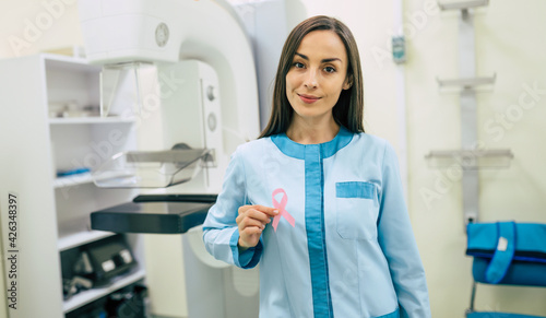 Cute professional woman doctor is working with modern Mammography X-Ray System Machine in a hospital or private clinic. Cancer and disease female treatment concept