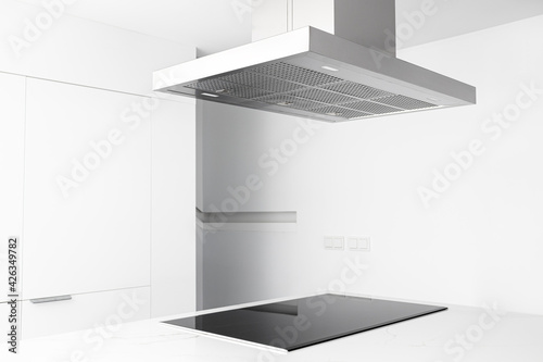 View of a cooker hood and electric stove of a modern and minimalist kitchen