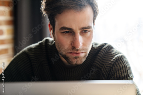 Mid aged man working on laptop computer from home