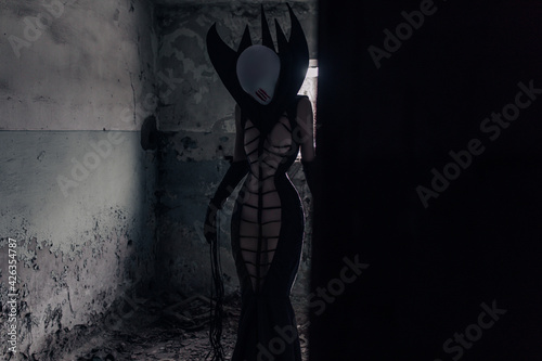 Woman portrays alien creature inside abandoned house.
