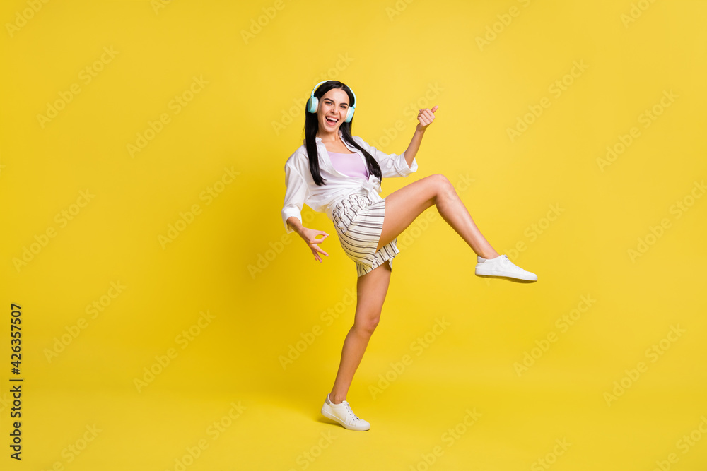 Full size profile side photo of happy funky woman hold play imagine guitar wear headset isolated on yellow color background