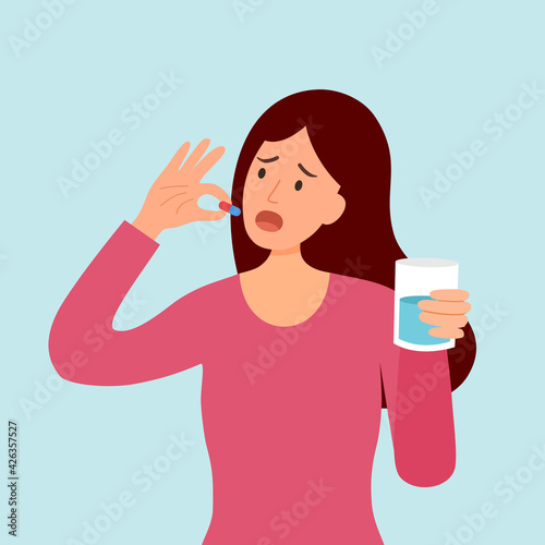 Woman taking medicine for illness treatment. Female take vitamin or supplement capsule pill with water.