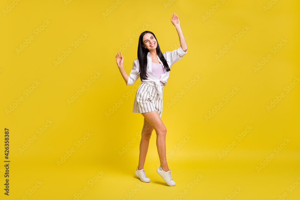 Full size photo of young excited smiling positive dreamy girl look copyspace dancing isolated on yellow color background Full size photo of young excited smiling positive dreamy girl look copyspace dancing isolated on yellow color background