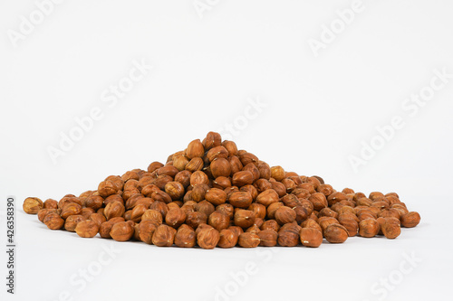 Hazelnuts isolated on white background. Peeled hazelnuts. Studio photo. Copy space.