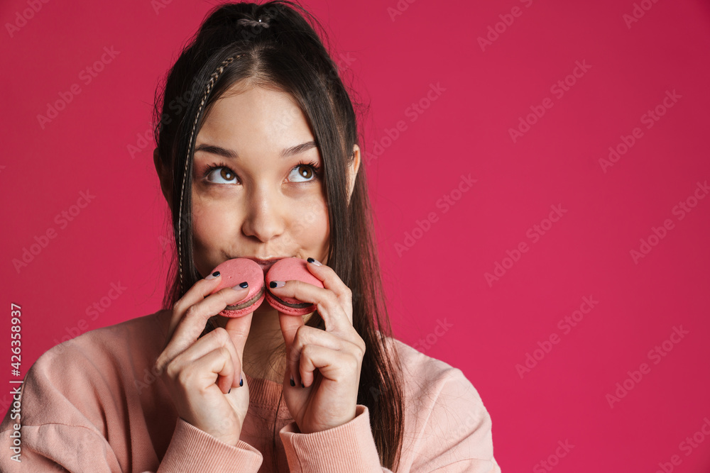 Asian brunette happy woman smiling while posing with macaroons