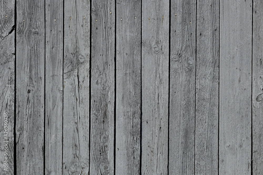 The texture of gray from old wooden planks arranged in a vertical order. Background for further design. Ancient building material. Rough relief texture of natural wood. Combustible insulating surface The texture of gray from old wooden planks arranged in a vertical order. Background for further design. Ancient building material. Rough relief texture of natural wood. Combustible insulating surface