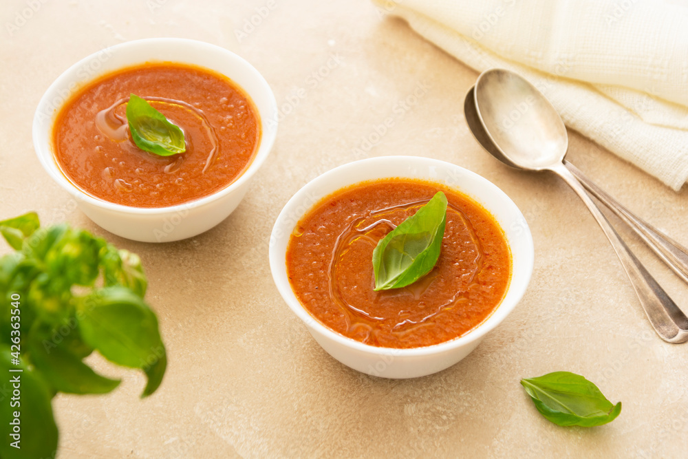 Gazpacho cold tomato soup bowl with basil, bright background. Gazpacho cold tomato soup bowl with basil, bright background.