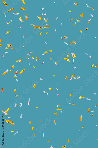 Golden silver sparkling confetti isolated on turquoise. Holiday effect