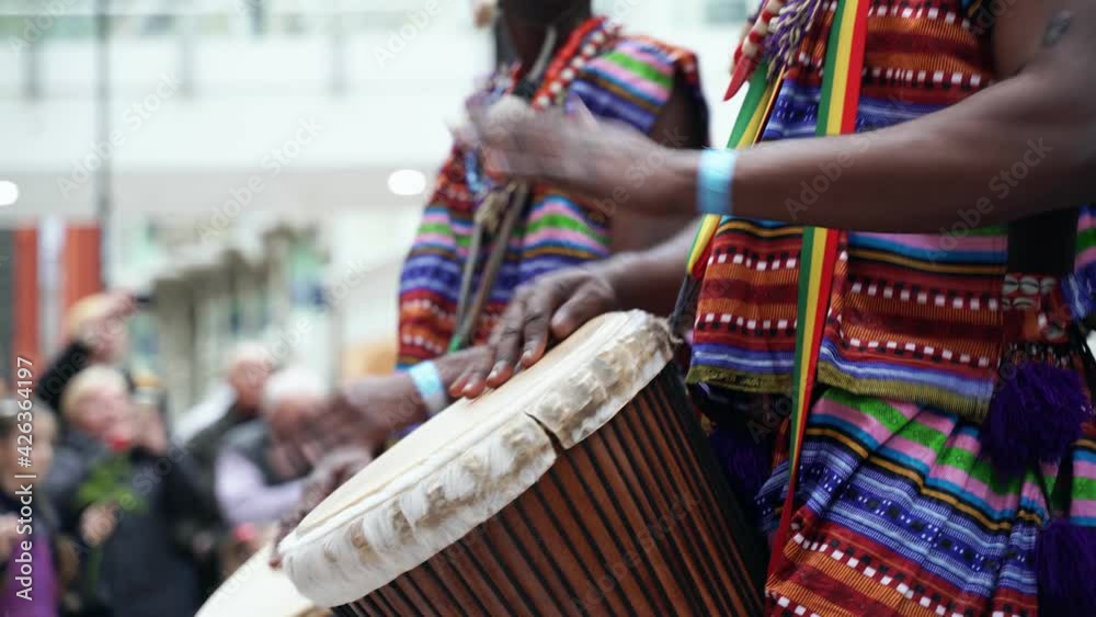 Man playing drum by his hands. Street performance using percussion instruments in slow motion