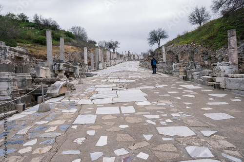 a man looking at historical Curetes Street with columns and statues around in Ephesus ruins, historical ancient Roman archaeological sites in eastern Mediterranean Ionia region