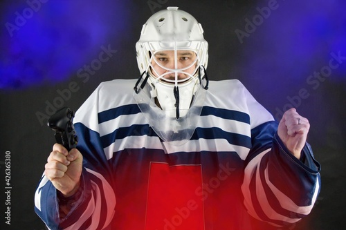 Man in hockey sport dress plays esports.Electronic sports are popular.Man in hockey sports dress holds a controller from the game console. Let`s play and qualify for the electronic sport Olympics.