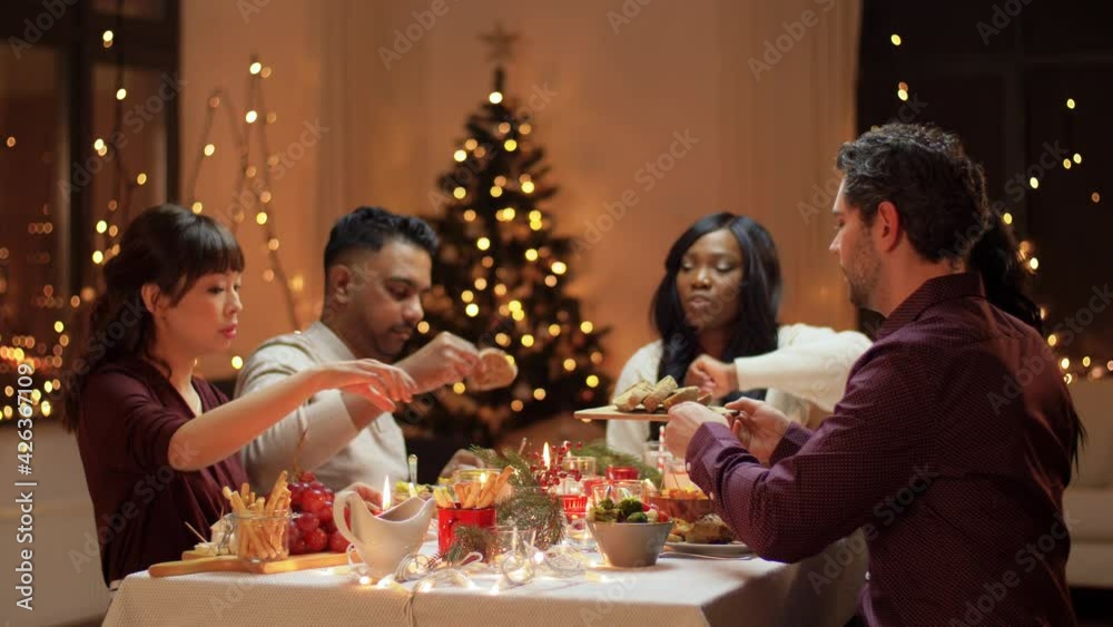 winter holidays, celebration and people concept - happy friends having christmas dinner at home