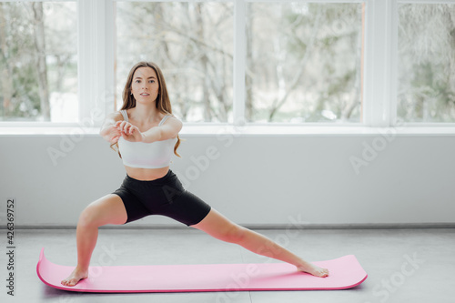 Beautiful girl in yoga studio. A woman doing a yoga. Lady in a top.