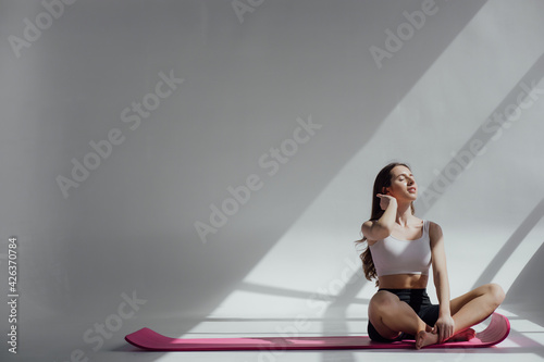 Portrait of body fitness trainer lady relaxing between exercise on gym mat with long hard spread. Dreaming about travelling.