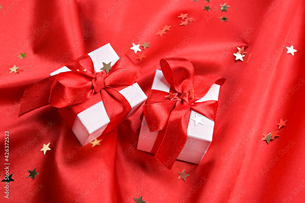 Gift box with a bow on a red background. Postcard for any holiday with free space for text. Surprise. High quality photo