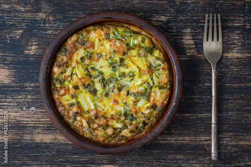 Ceramic bowl with vegetable frittata, simple vegetarian food. Frittata with egg, pepper, green onions and cheese . Healthy egg omelet