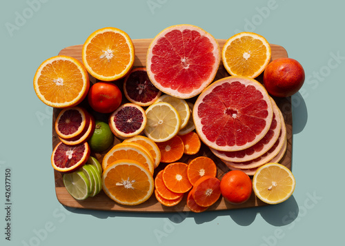 Set of different sliced citrus fruits on wooden board. Orange  grapefruit  lime  tangerine  lemon. Organic SPA cosmetics with orange oil and vitamin C.