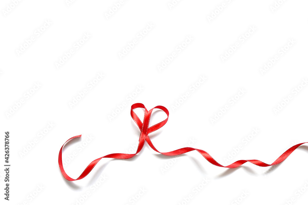 narrow red satin ribbon folded into a heart on a white background narrow red satin ribbon folded into a heart on a white background