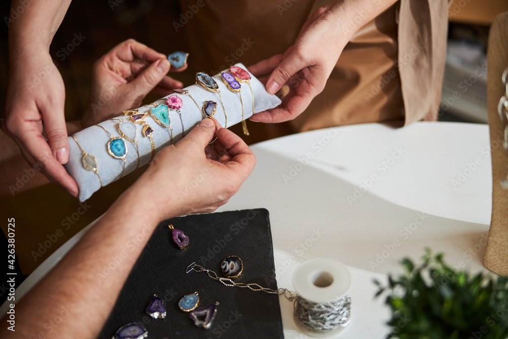 Obraz premium Artisan picking the right gemstone bracelets for his earrings