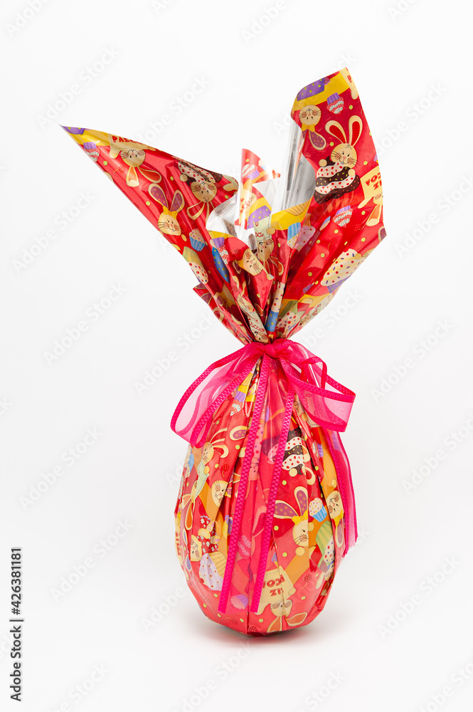 Easter Egg - Homemade chocolate egg with red ribbon. Isolated on white background. Vertical shot.