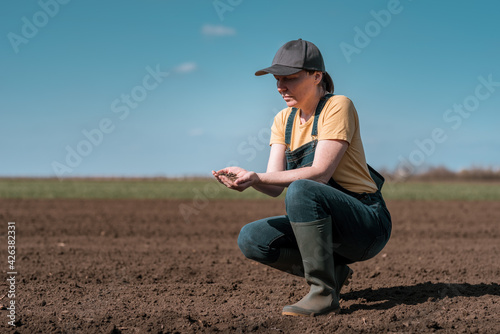 Photos Female farmer agronomist checking the quality of ploughed field soil before sowi