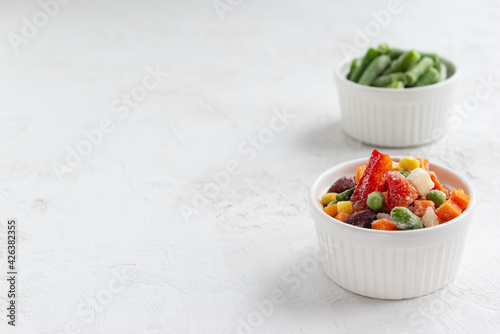 Frozen vegetables in white bowls. Horizontal orientation, copy space.