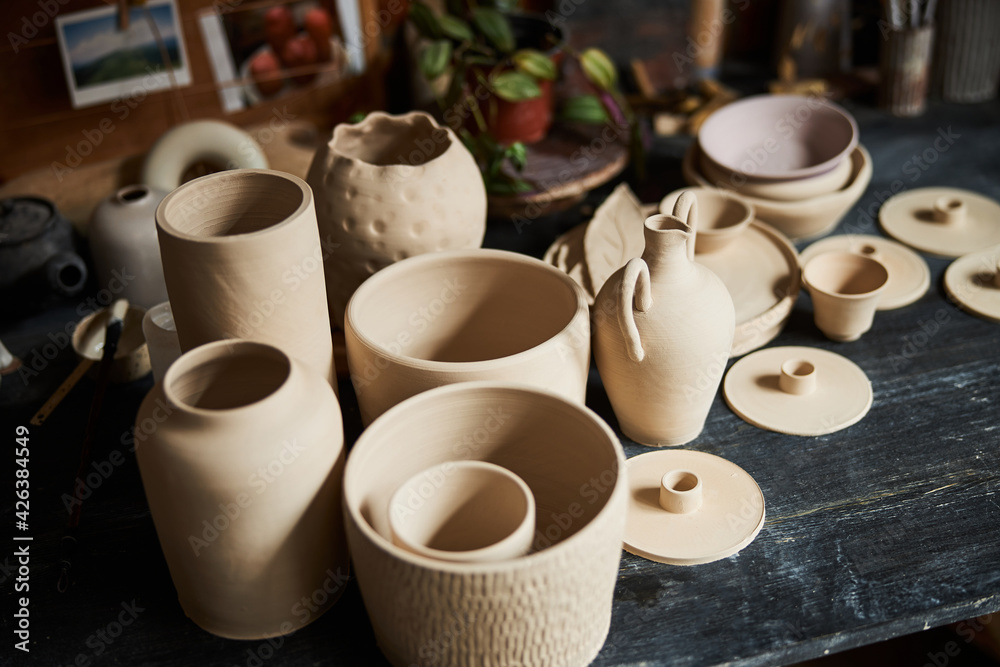 Handmade pottery on wooden table in workshop Handmade pottery on wooden table in workshop