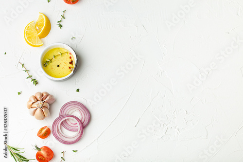 Food cooking background on white stone rustic table with fresh ingredients, vegetables, herbs, spices, olive oil from above with space for text