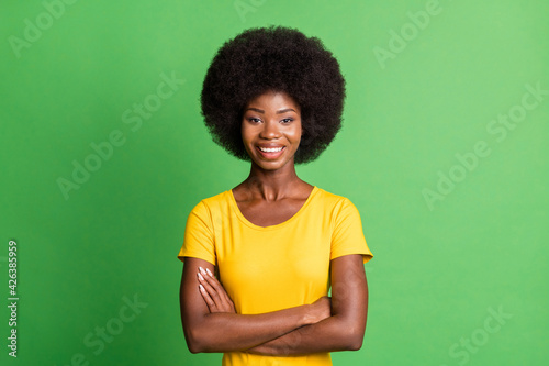 Photo of young happy cheerful good mood confident cool afro girl with folded hands isolated on green color background