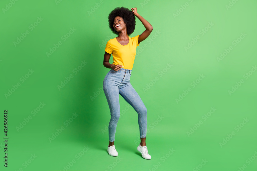 Full length body size photo of dancing overjoyed girl laughing at party isolated on vibrant green color background Full length body size photo of dancing overjoyed girl laughing at party isolated on vibrant green color background
